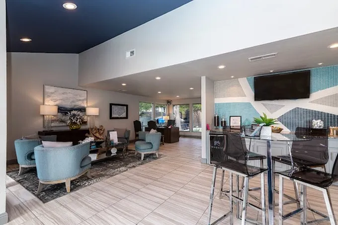 Clubhouse, open lounge, high-top seating, wall-mounted TV, large windows