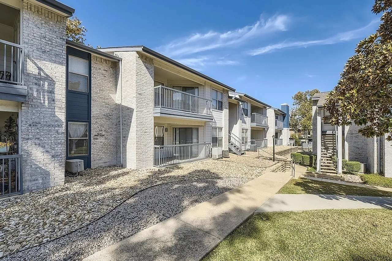 Apartment building exterior, balconies, gravel landscaping, walkway