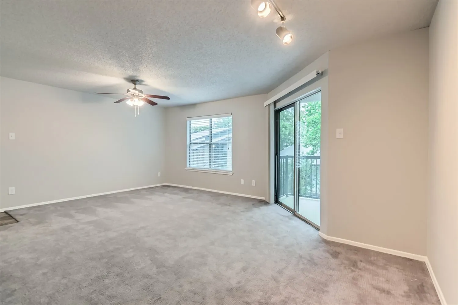 Living room, ceiling fan, window, sliding glass door, carpet flooring