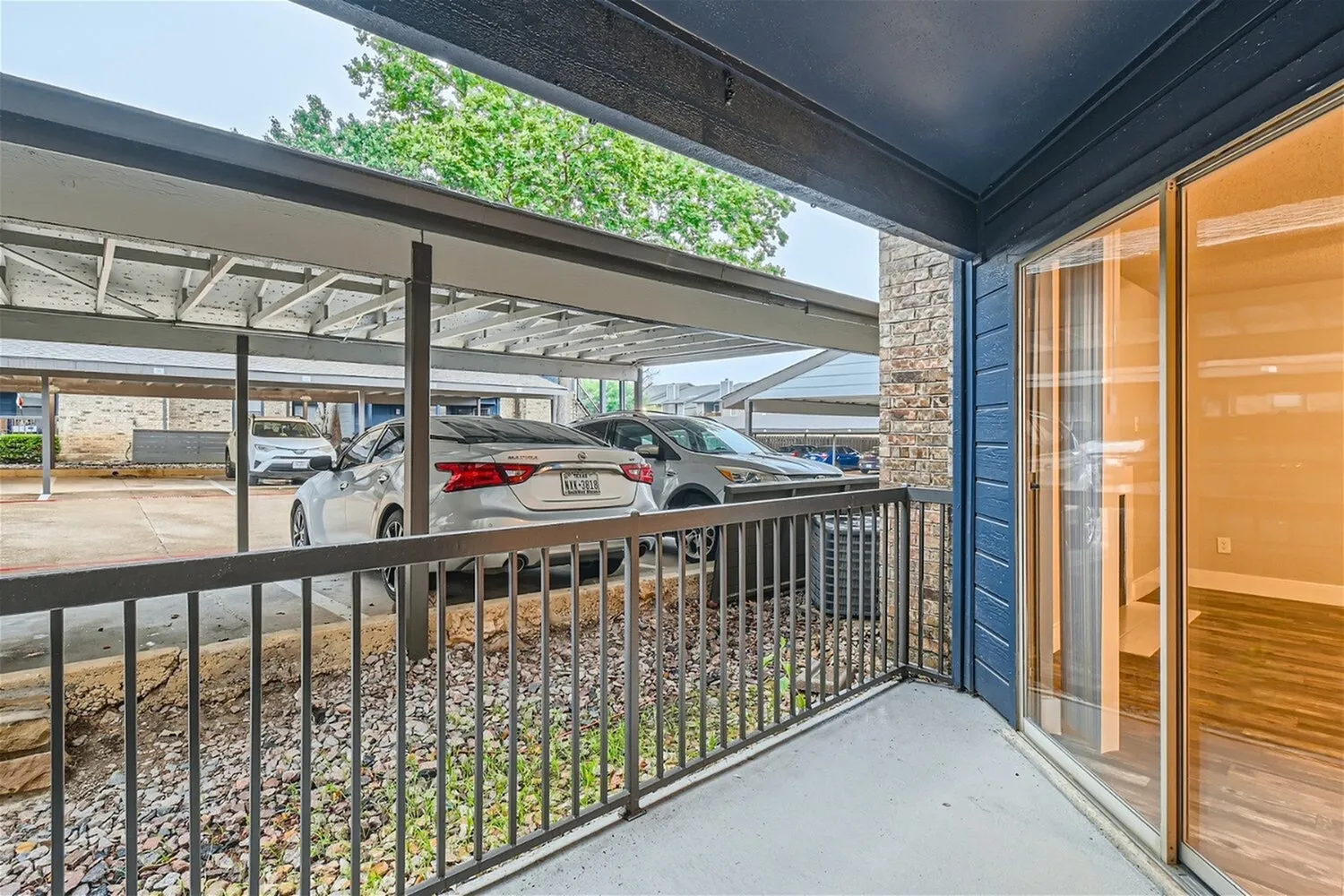 Patio, metal railing, covered parking view, blue exterior wall