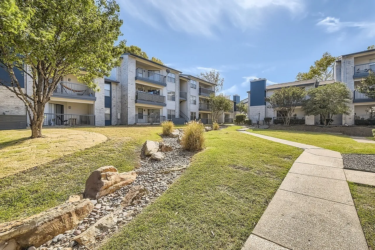 Landscaped courtyard, rock feature, walkway, building exteriors