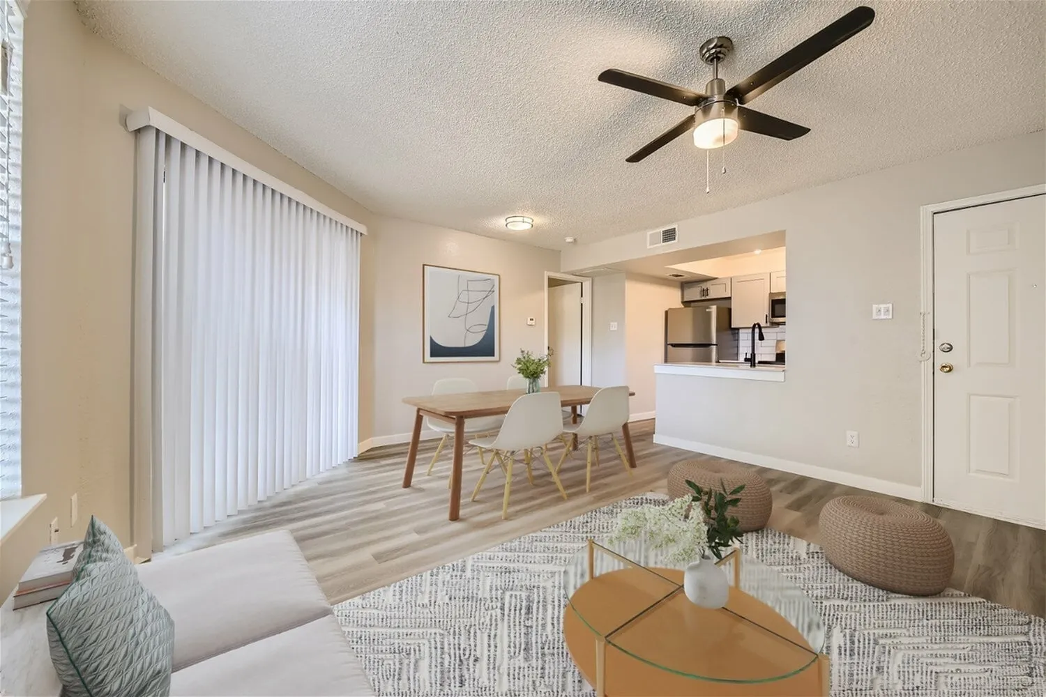 A1 Platinum open living and dining area, ceiling fan, vertical blinds, wood-style plank flooring, kitchen beyond