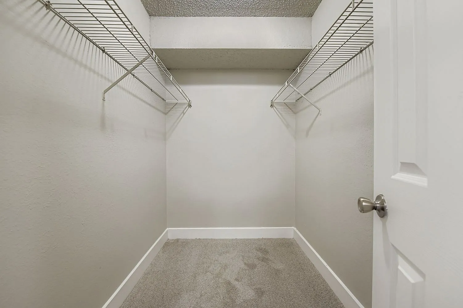 Walk-in closet, wire shelving, carpet flooring