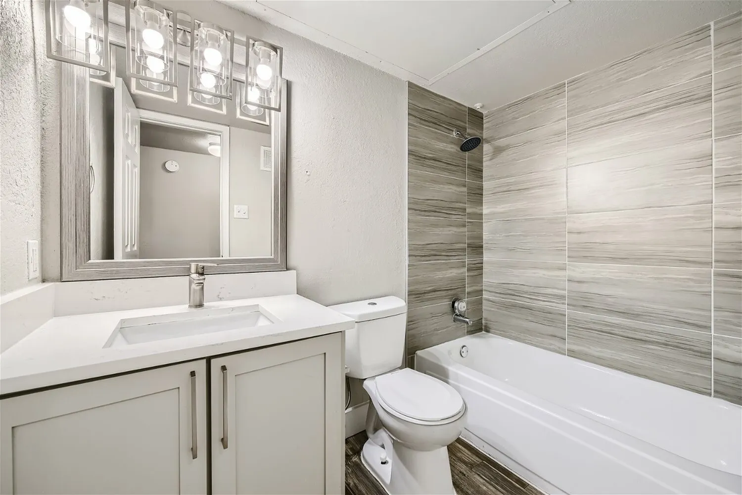 Bathroom, vanity, framed mirror, tub shower, wood-look tile surround