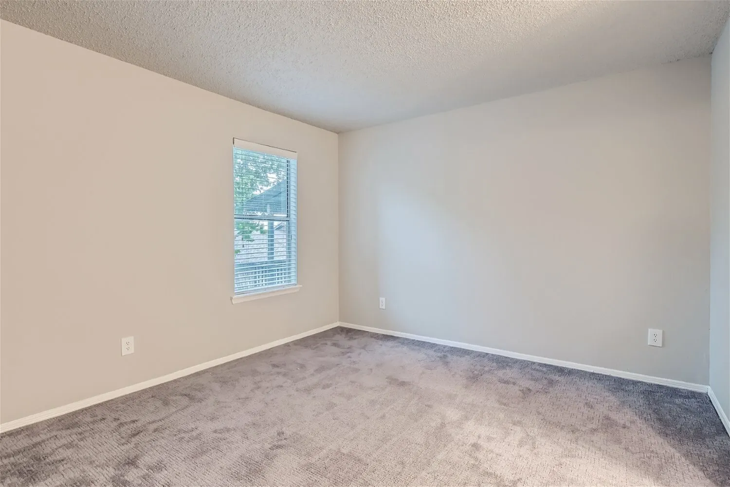 Bedroom, window with blinds, carpet flooring, neutral walls