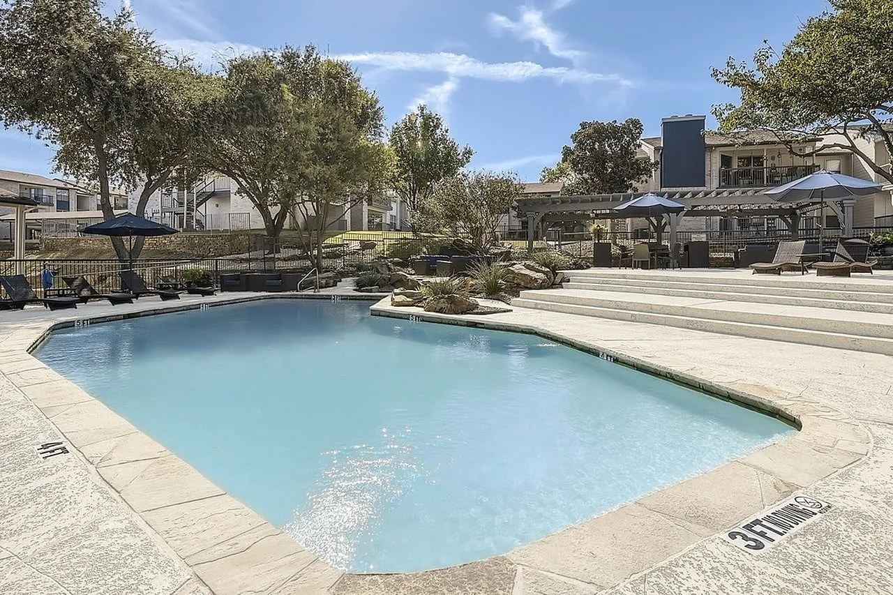 Pool, stepped seating area, rock accents, pergola in background