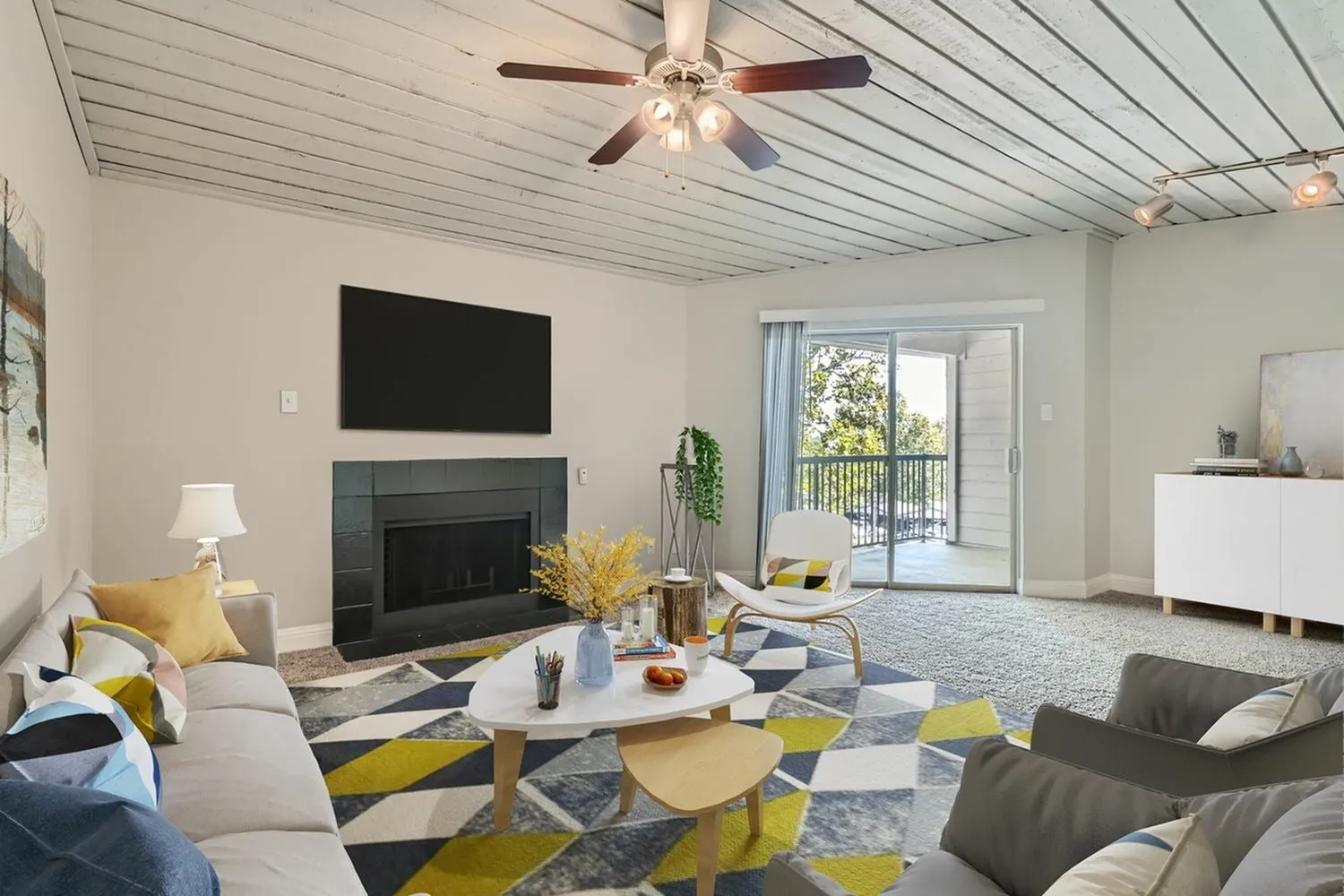 A2 Bronze living room, fireplace, plank ceiling, sliding glass door to balcony, carpet flooring