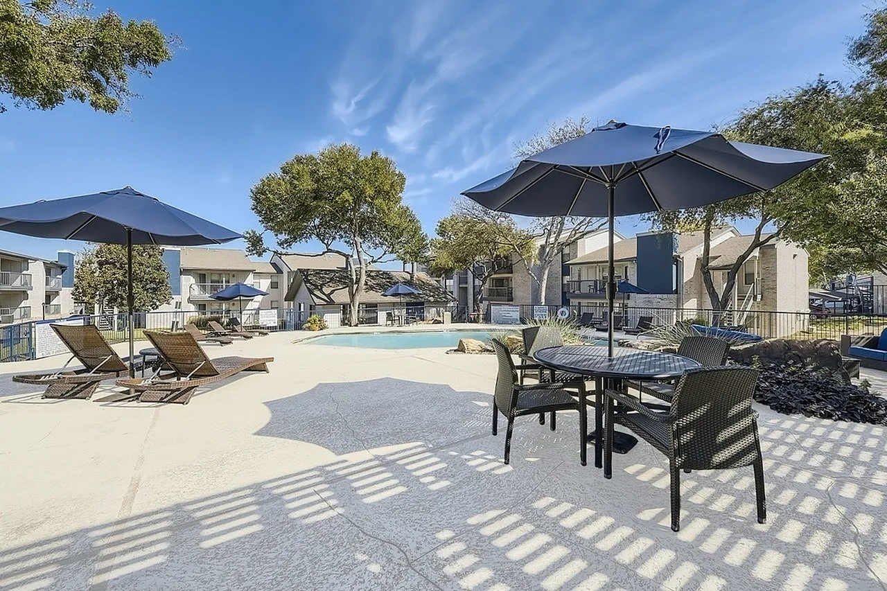 Poolside patio table, patio umbrella, lounge chairs, mature trees