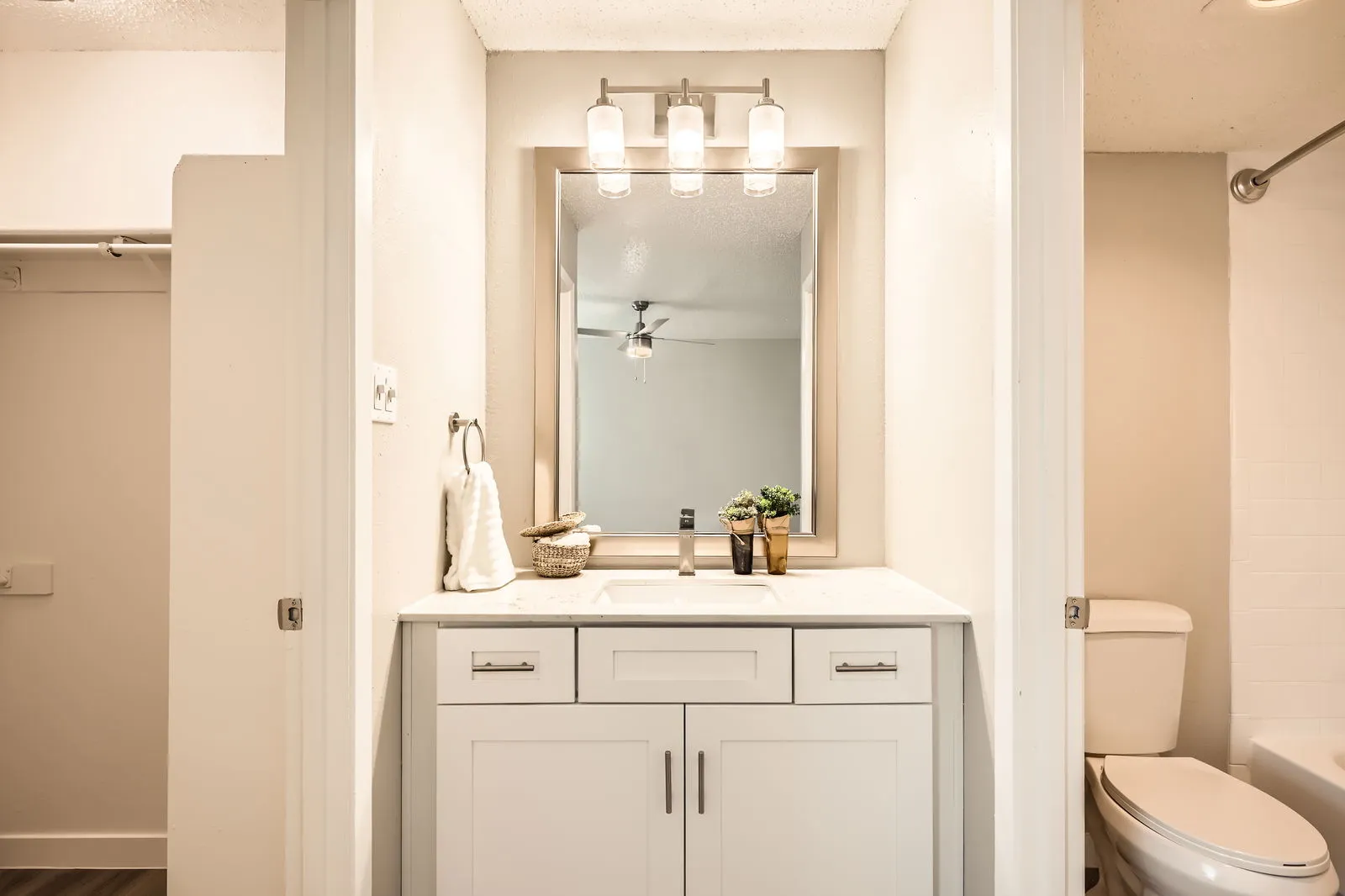 Primary bathroom vanity with framed mirror and vanity lighting