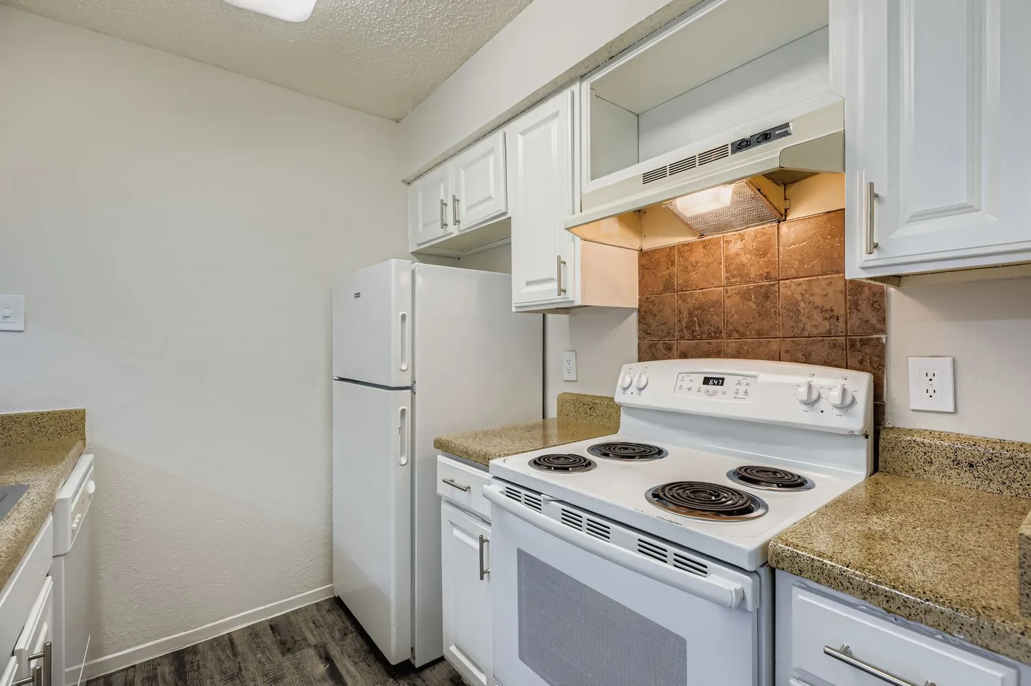 Kitchen with white cabinetry, white appliances, and tile backsplash