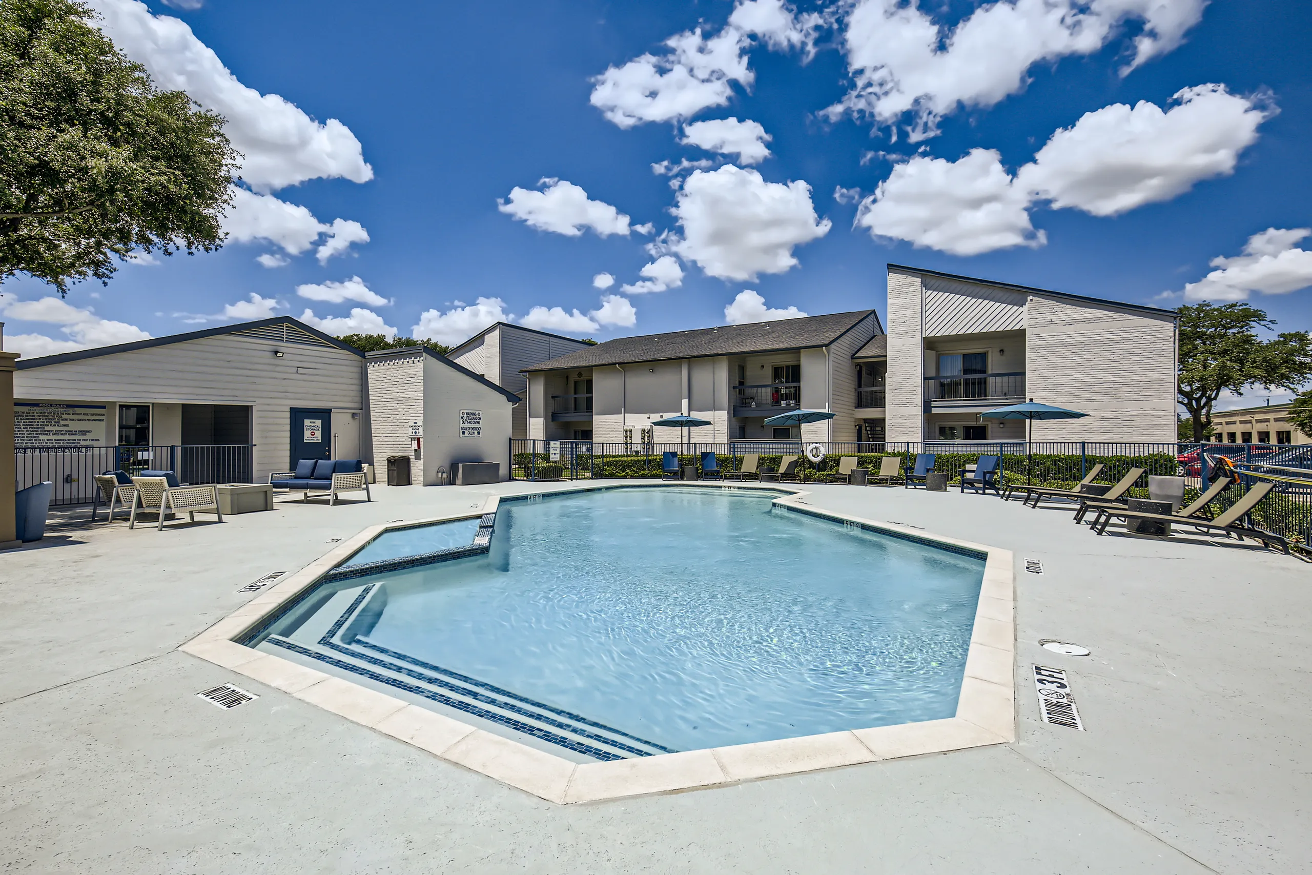 Swimming pool with pool rules signage and lounge seating