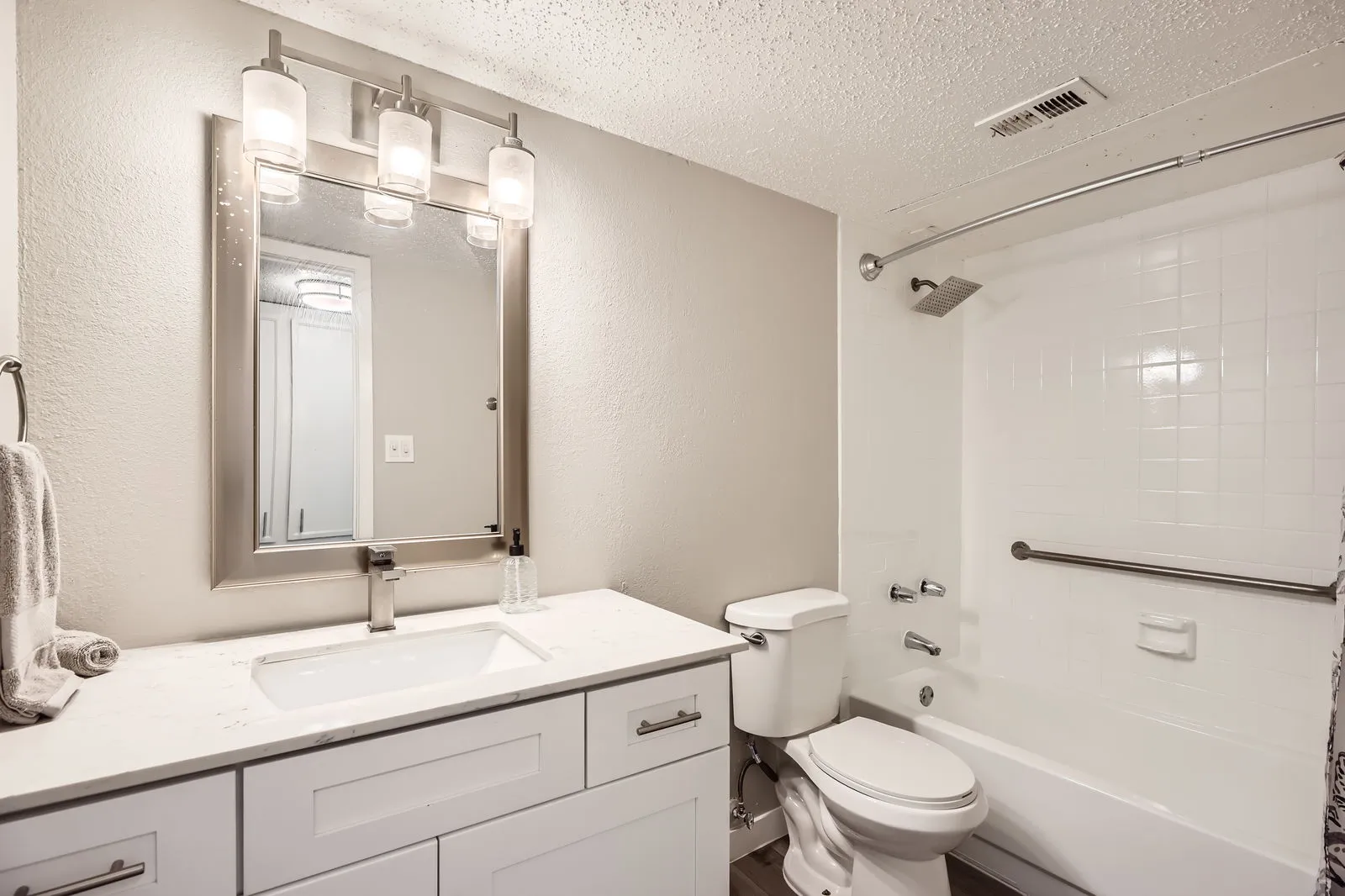 Bathroom vanity with tub and shower combo featuring rainfall showerhead