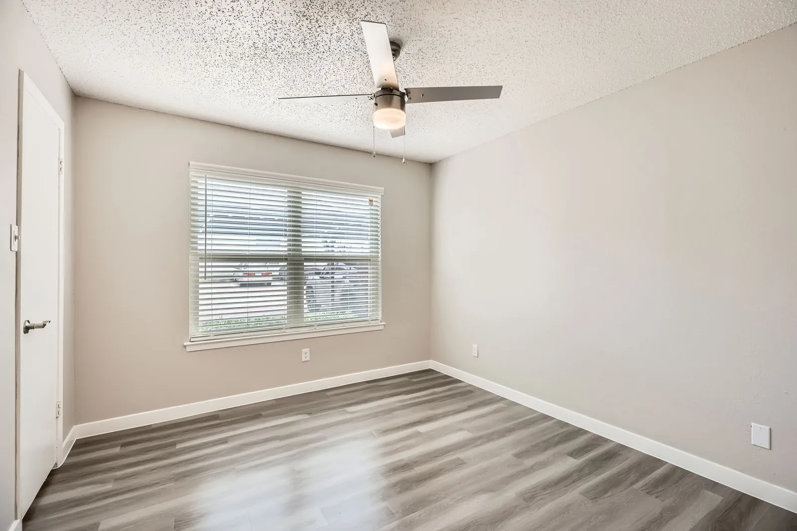 Secondary bedroom with wood-style plank flooring and window