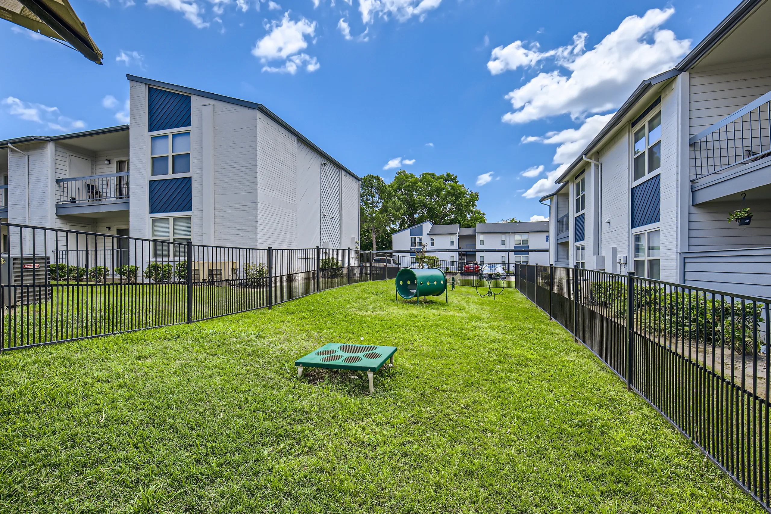 Fenced pet-friendly park with agility tunnel and play equipment