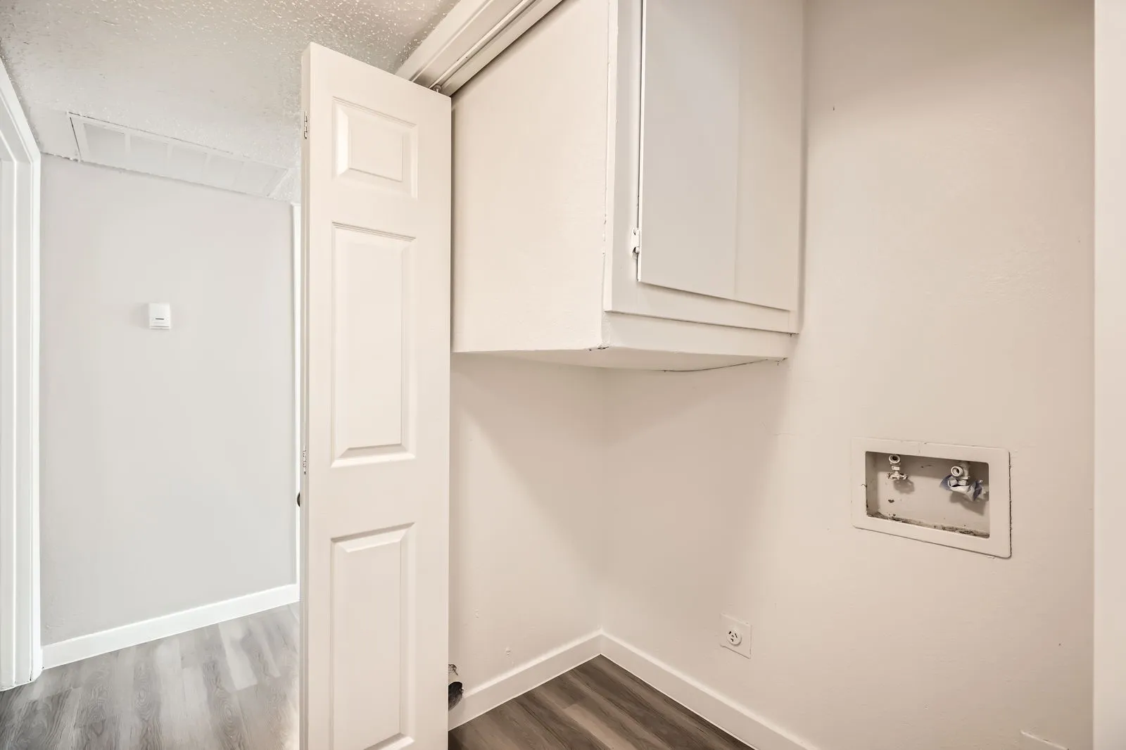 Laundry closet with cabinet storage and washer/dryer hookups