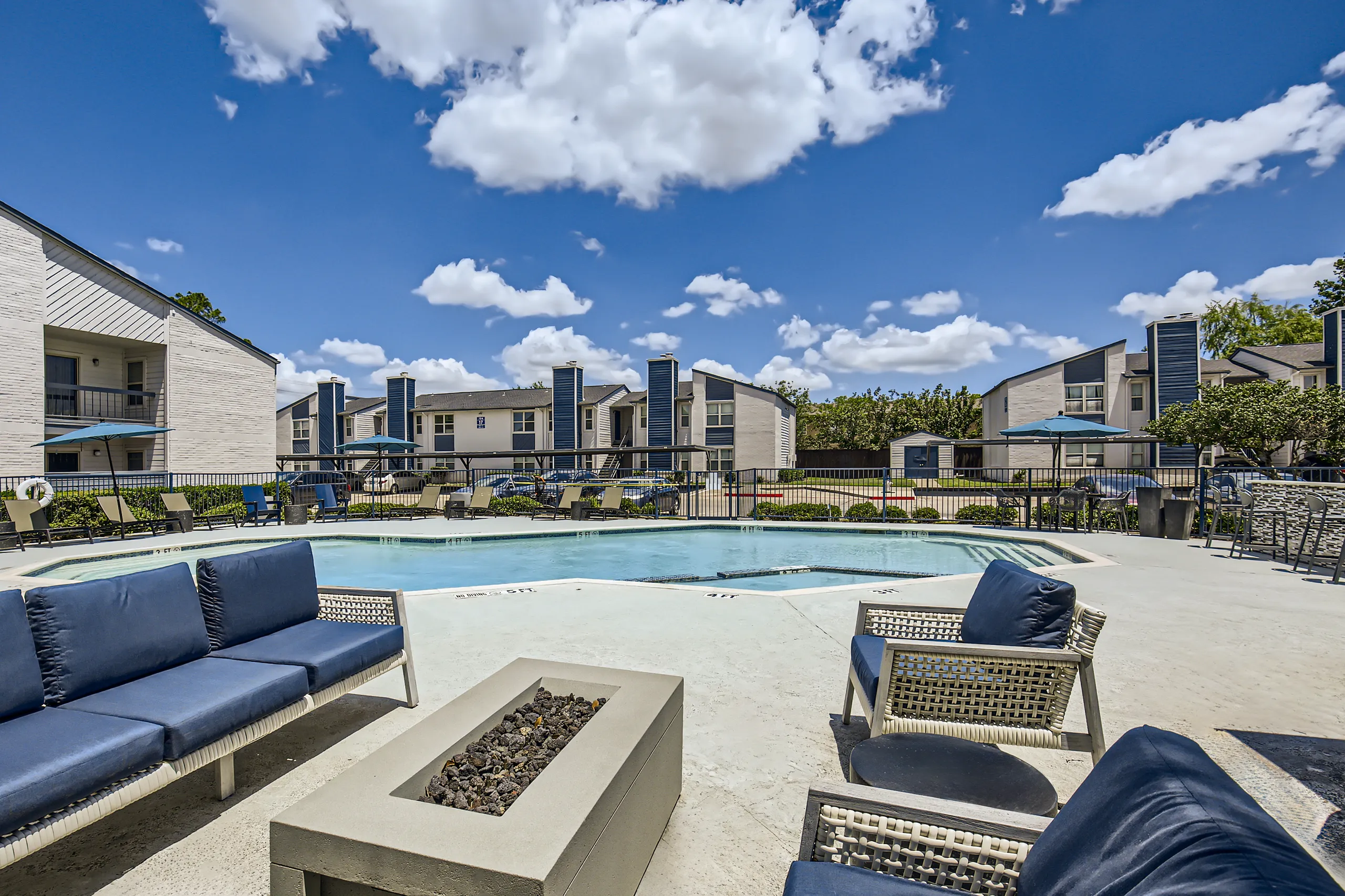Poolside lounge area with fire pit and outdoor sofa seating