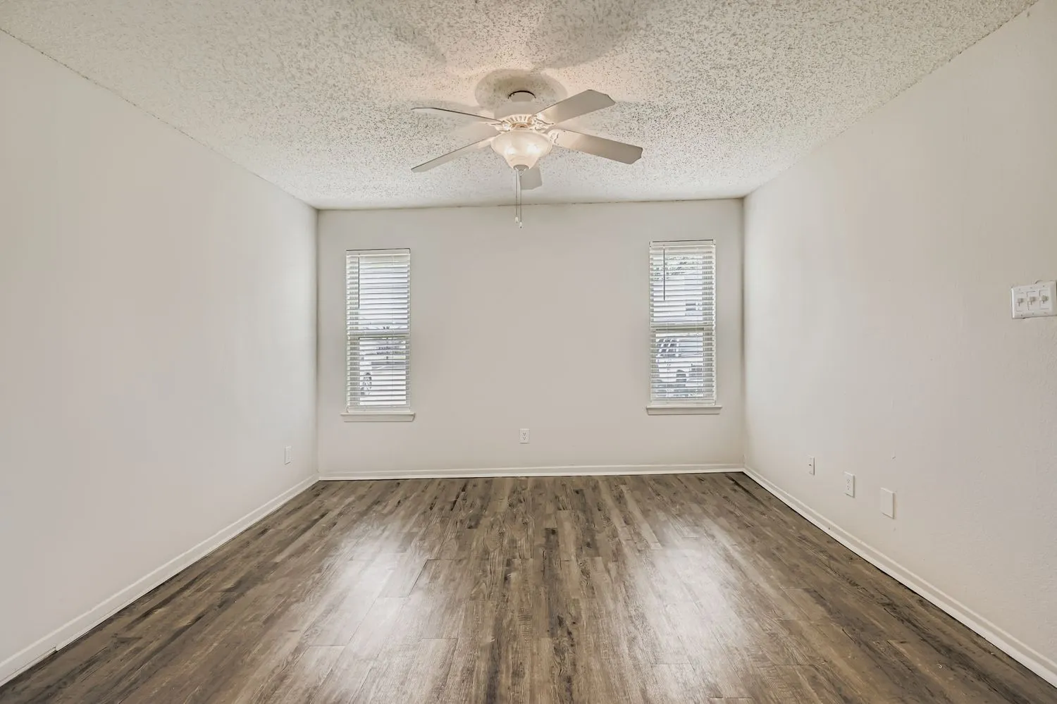 Living room corner with dual windows and ceiling fan