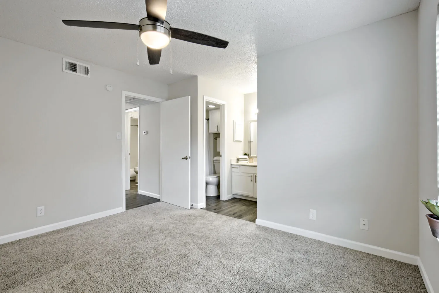 Primary bedroom with view into ensuite bathroom and closet