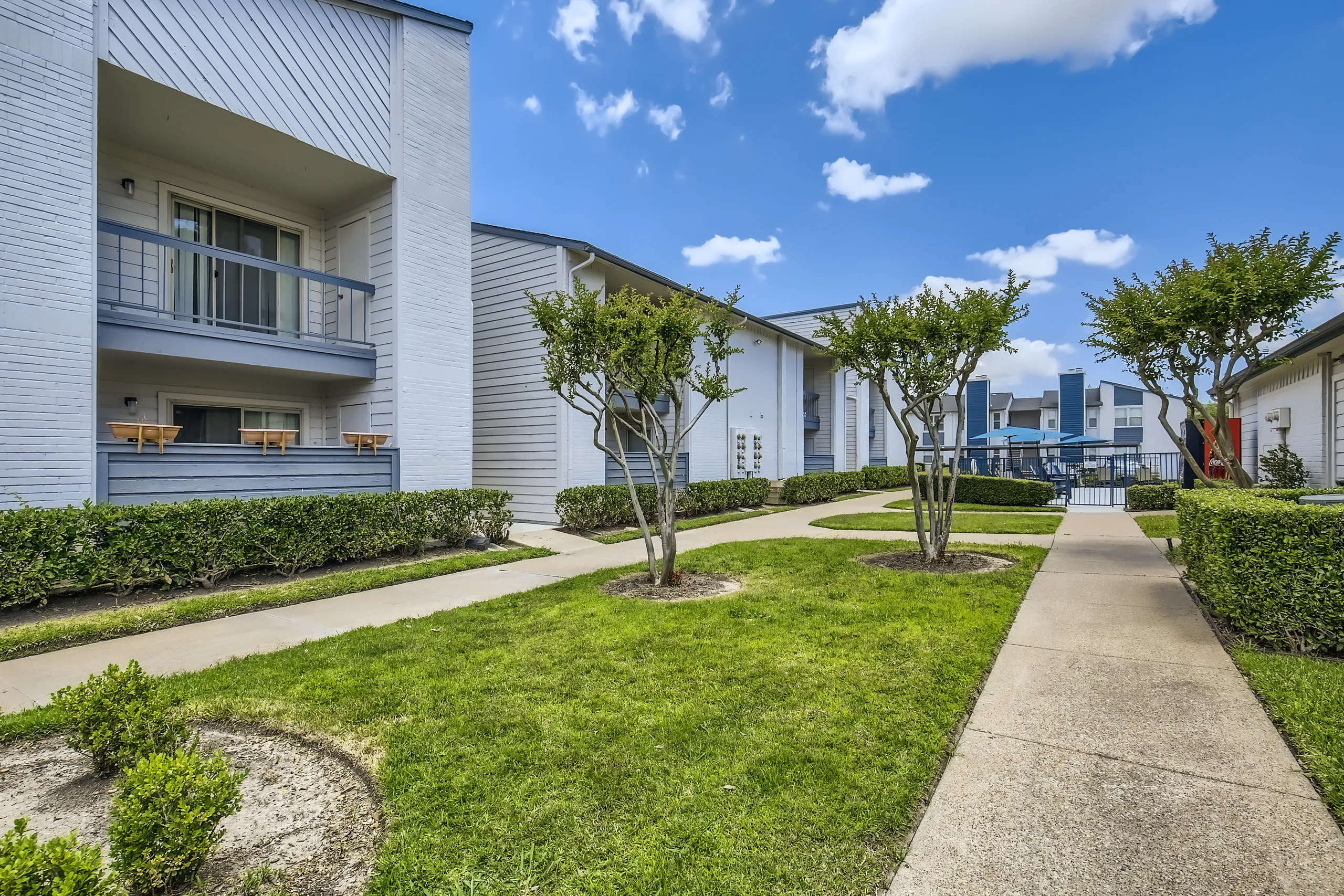 Landscaped courtyard walkway between apartment buildings