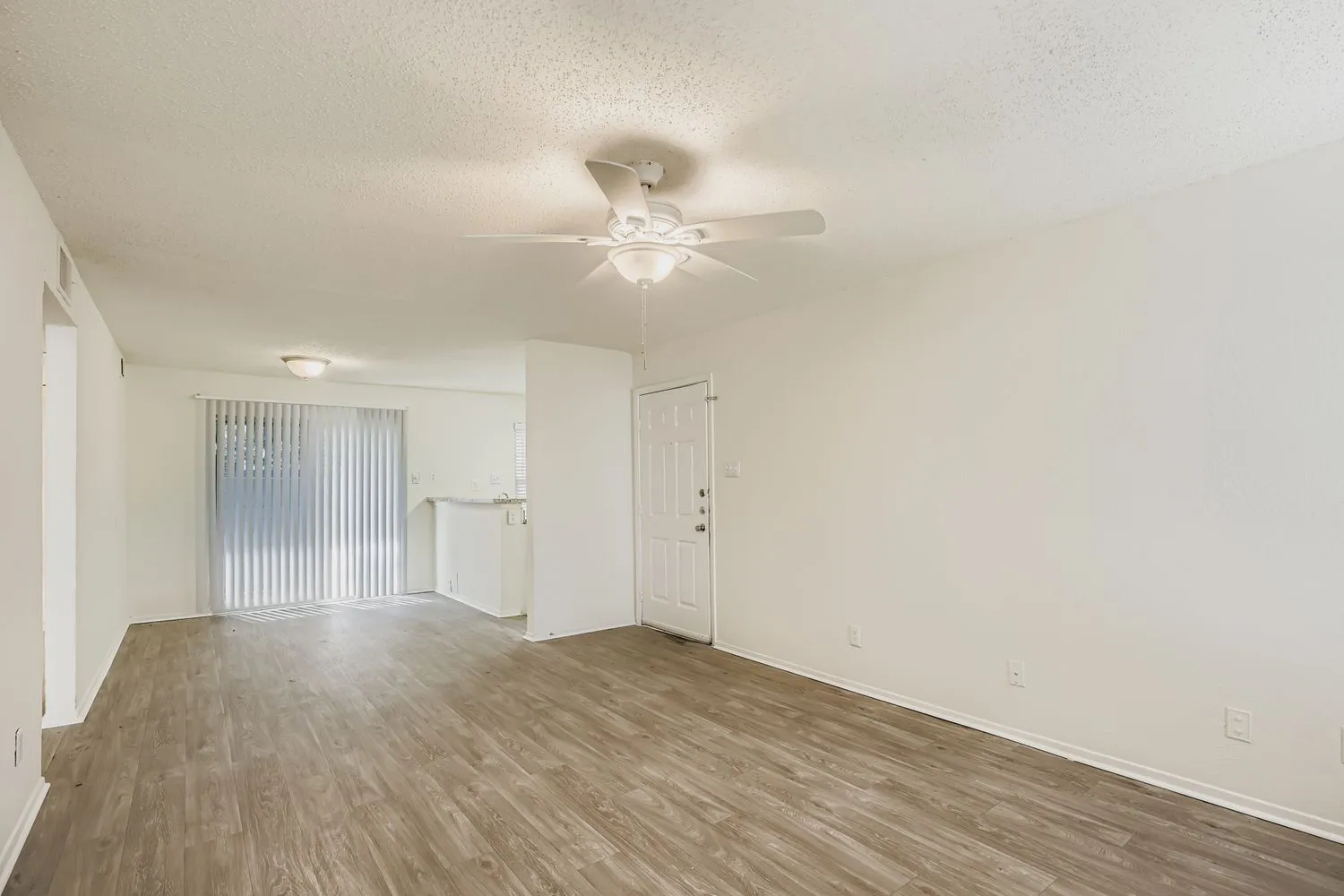 Living room with sliding glass door and entry hallway