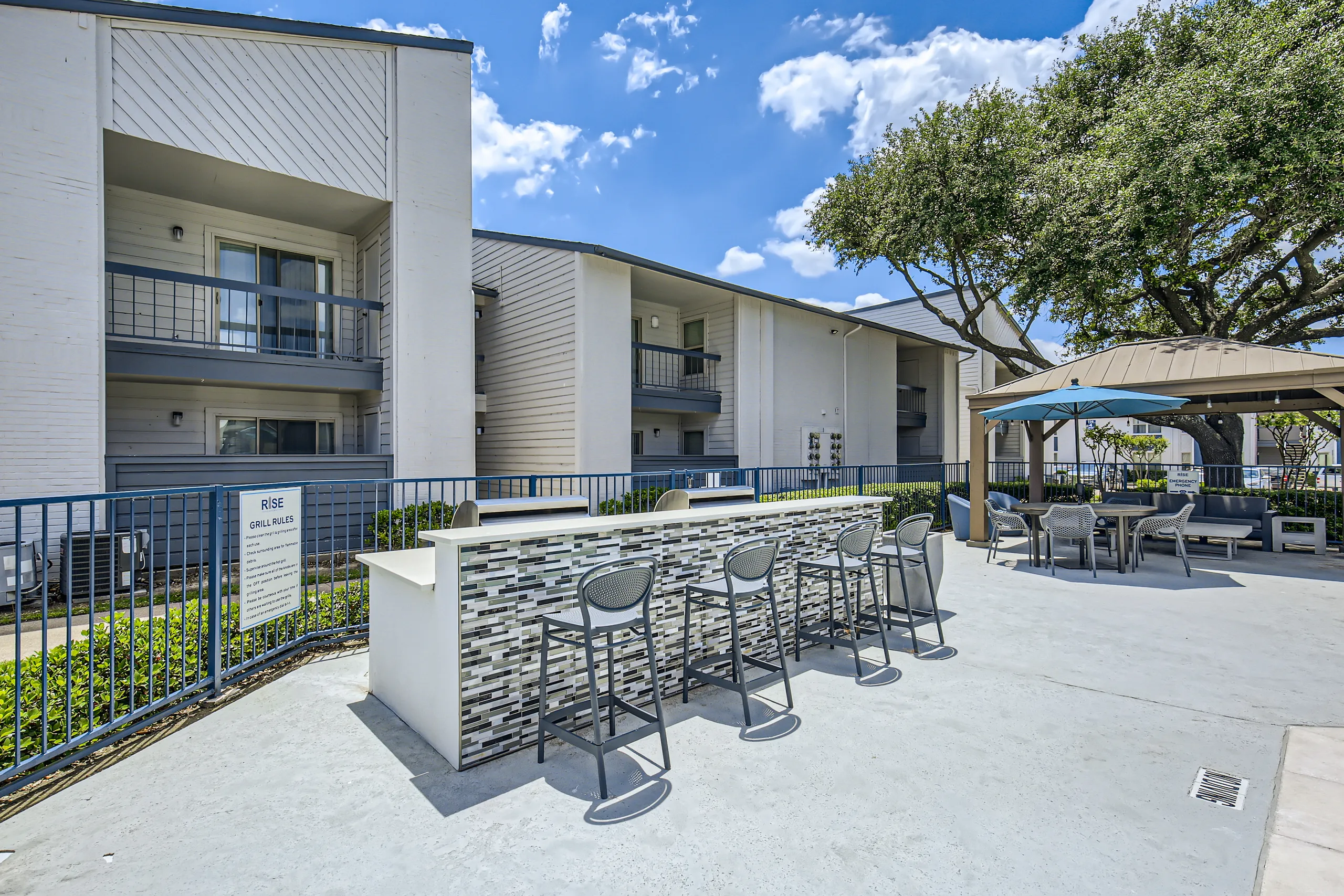 Outdoor grilling station with bar seating and tile countertop