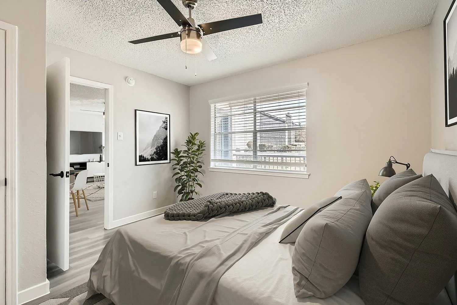 Primary bedroom, wood-style plank flooring, ceiling fan with light, windows with horizontal blinds
