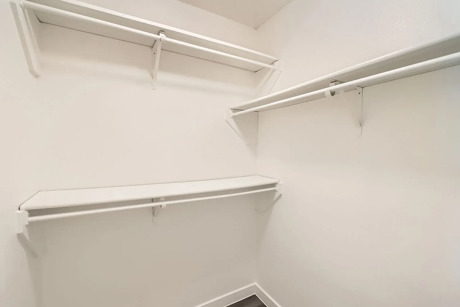 Walk-in closet, white shelving and rods, minimalist design
