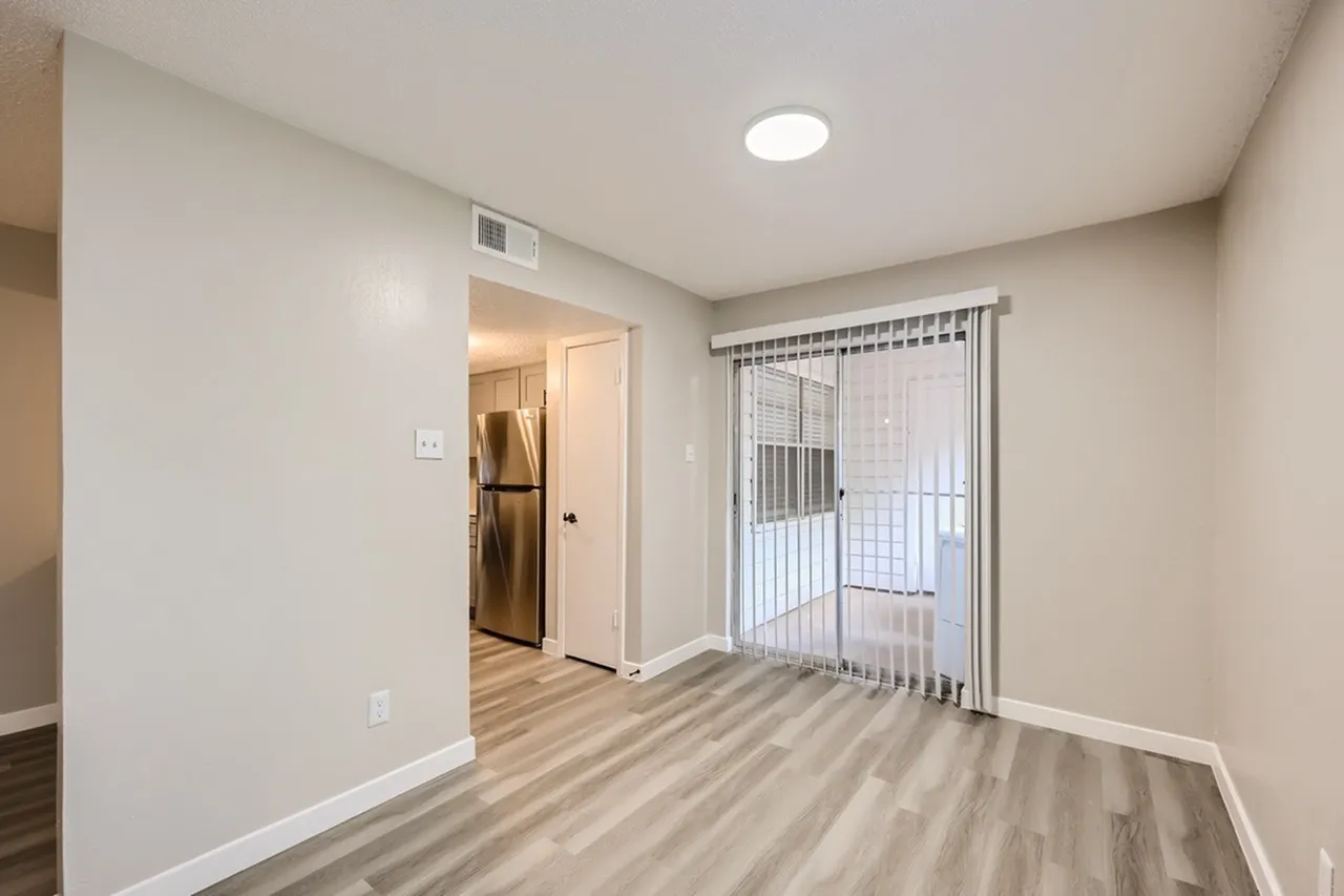 Living room, wood-style plank flooring, vertical blinds door to patio, recessed ceiling light