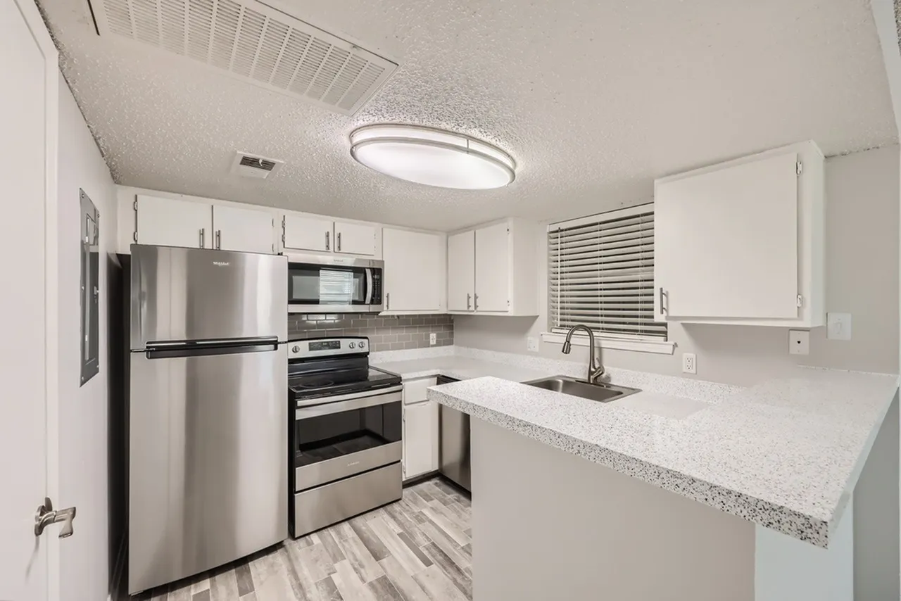 Kitchen, white shaker cabinetry, quartz countertops, stainless steel appliances, wood-style plank flooring