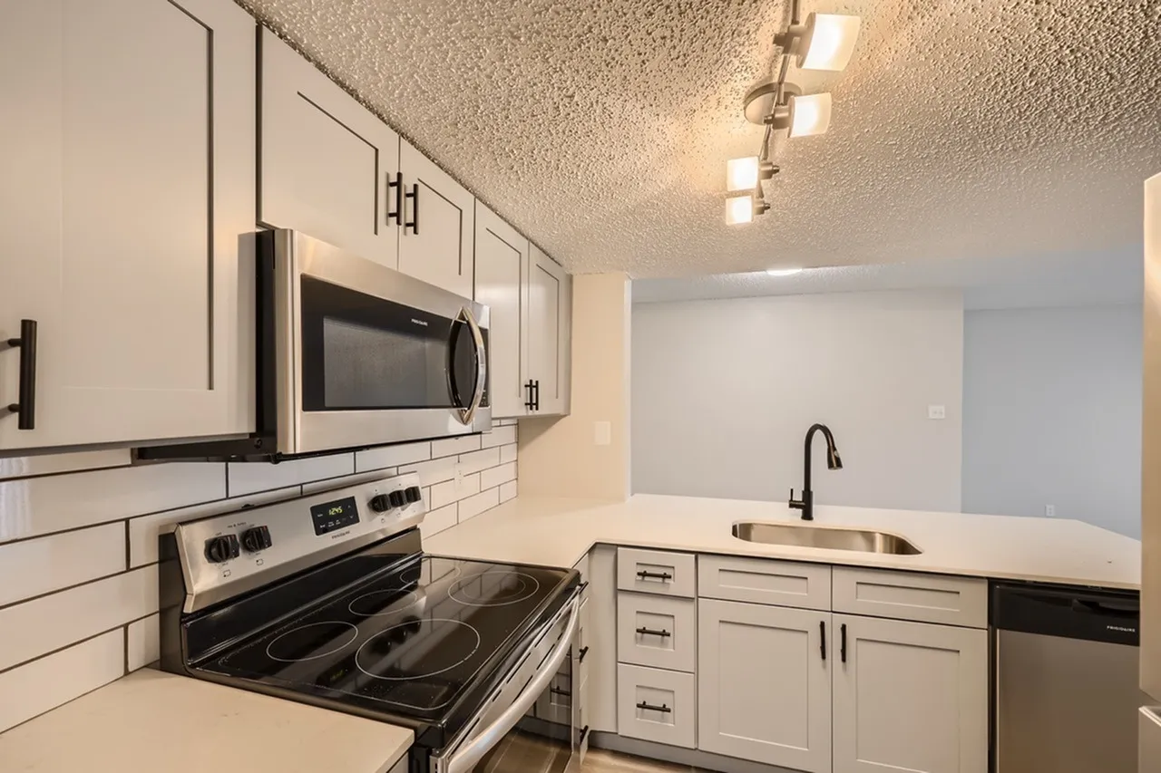 Kitchen, white shaker cabinetry, white subway tile backsplash, stainless appliances, quartz countertops