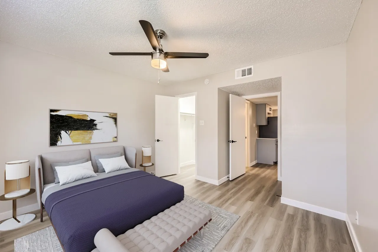 Primary bedroom, wood-style plank flooring, upholstered headboard, ceiling fan with light fixture