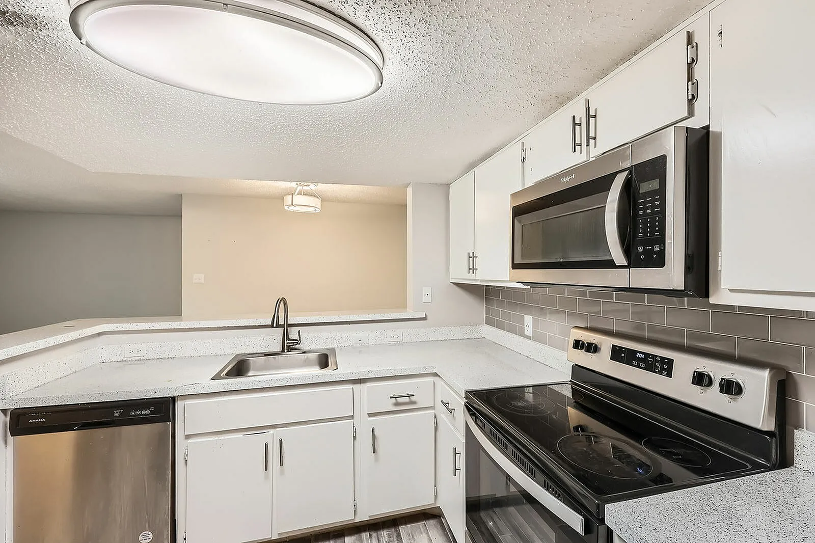 Kitchen, white shaker cabinetry, gray subway tile backsplash, quartz countertops, stainless appliances