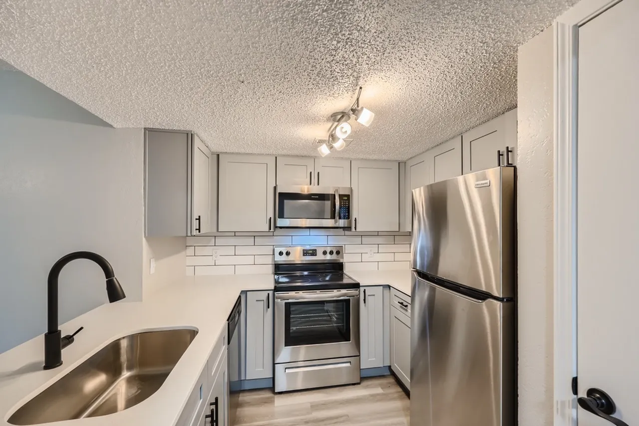 Kitchen, white shaker cabinetry, subway tile backsplash, stainless steel appliances, wood-style plank flooring