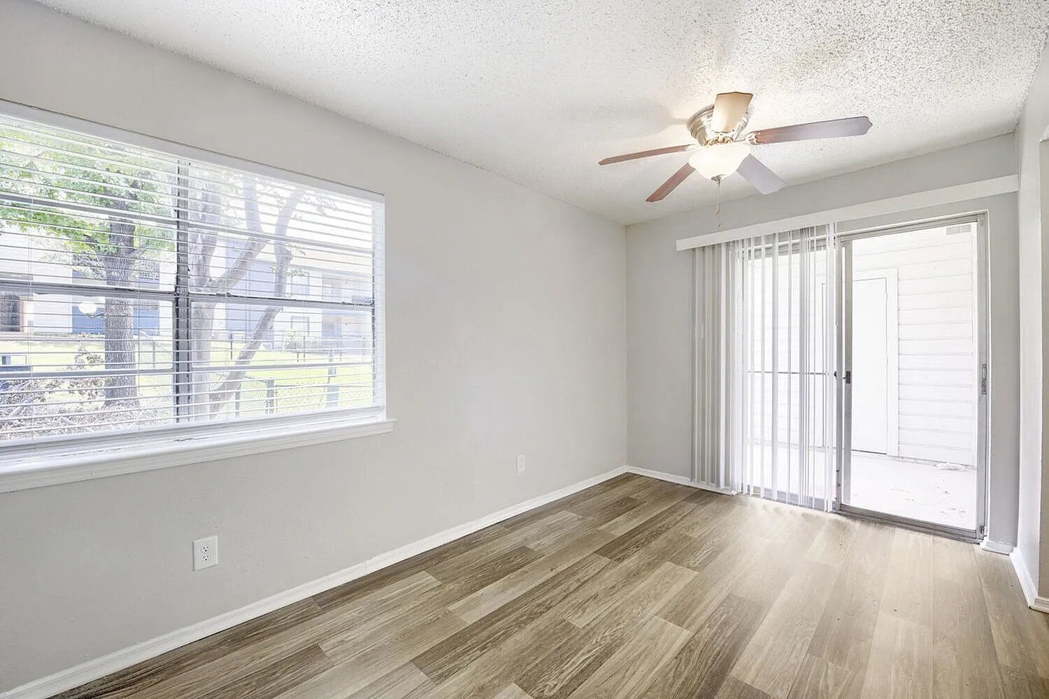 Bedroom, wood-style plank flooring, ceiling fan, sliding glass doors, large window