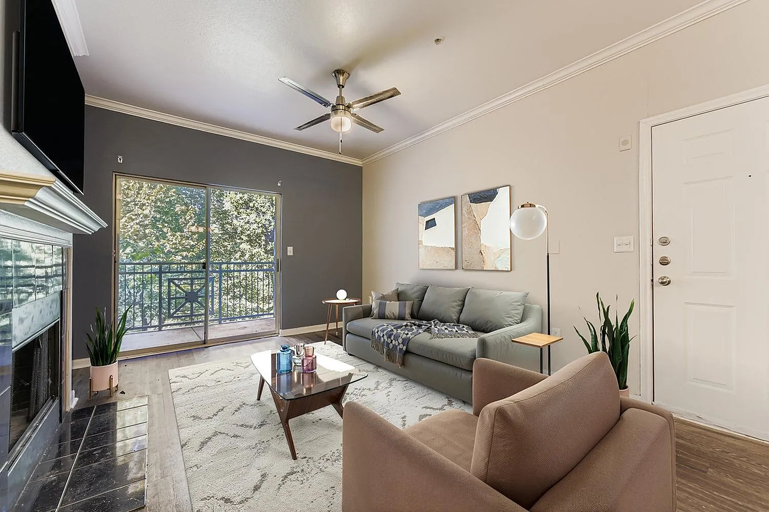 Living room, wood-style plank flooring, gray accent wall, ceiling fan, glass sliding doors