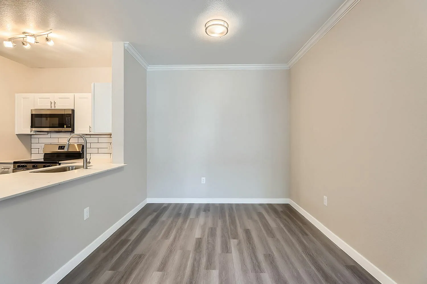 Dining room with wood-style plank flooring, white subway tile backsplash, stainless appliances, recessed lighting