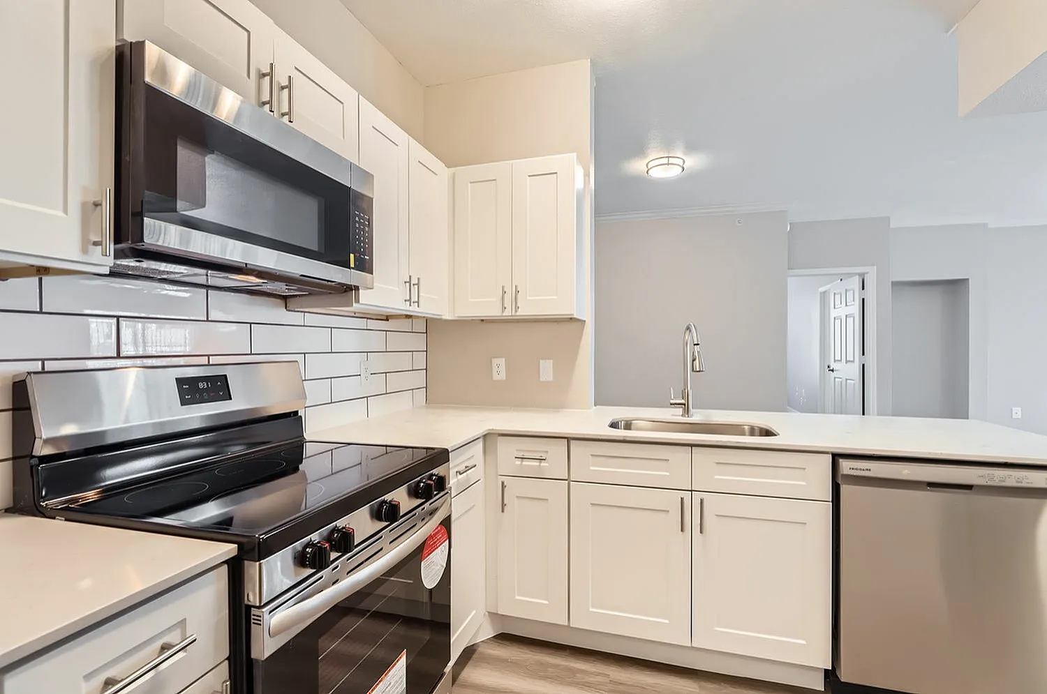Kitchen, white shaker cabinetry, subway tile backsplash, stainless steel appliances, quartz countertops
