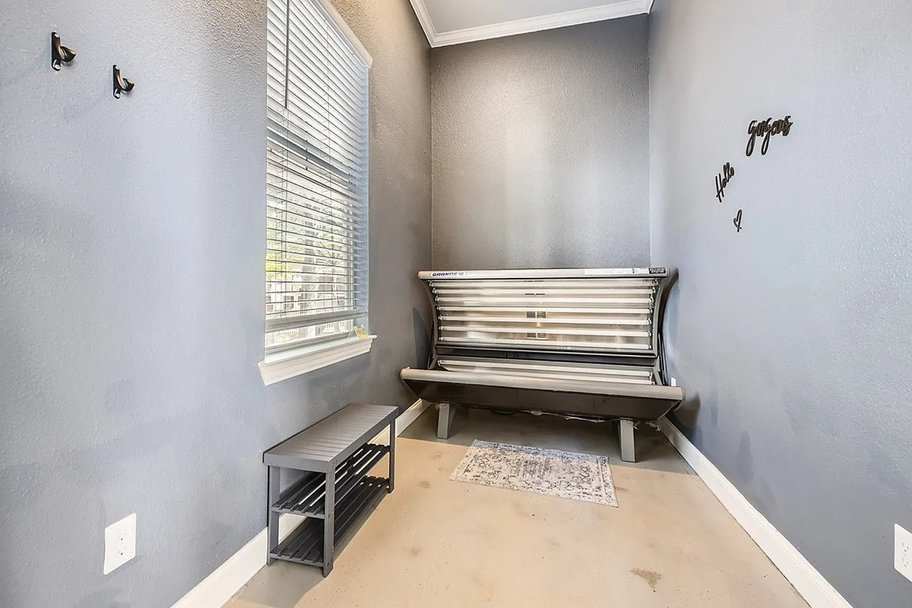 Tanning room, horizontal tanning bed, vinyl plank flooring, louvered window, wall decor
