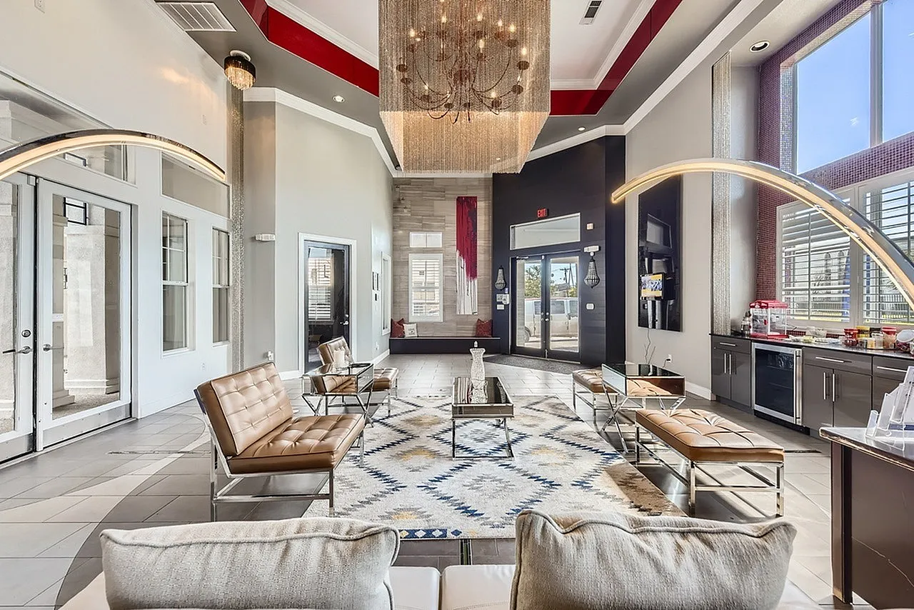 Upscale lobby with contemporary furnishings, two-story ceiling with chandelier, wood-style plank flooring, modern seating areas