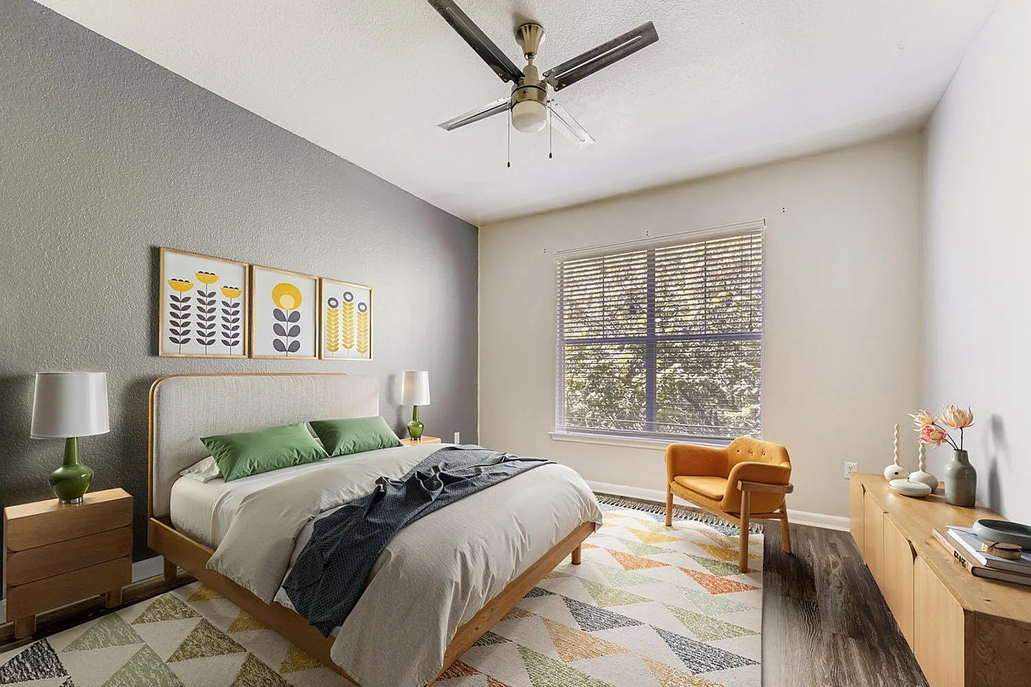 Primary bedroom, wood-style plank flooring, ceiling fan, geometric area rug, green accent pillows
