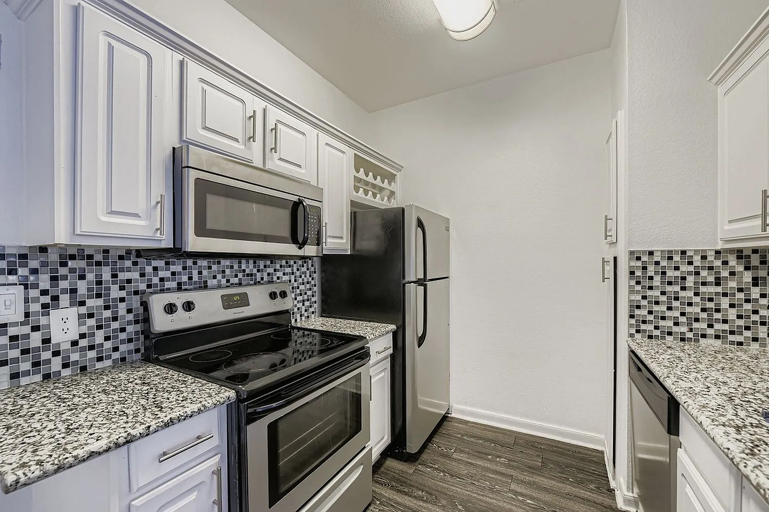 Kitchen, white shaker cabinetry, granite countertops, stainless appliances, mosaic tile backsplash
