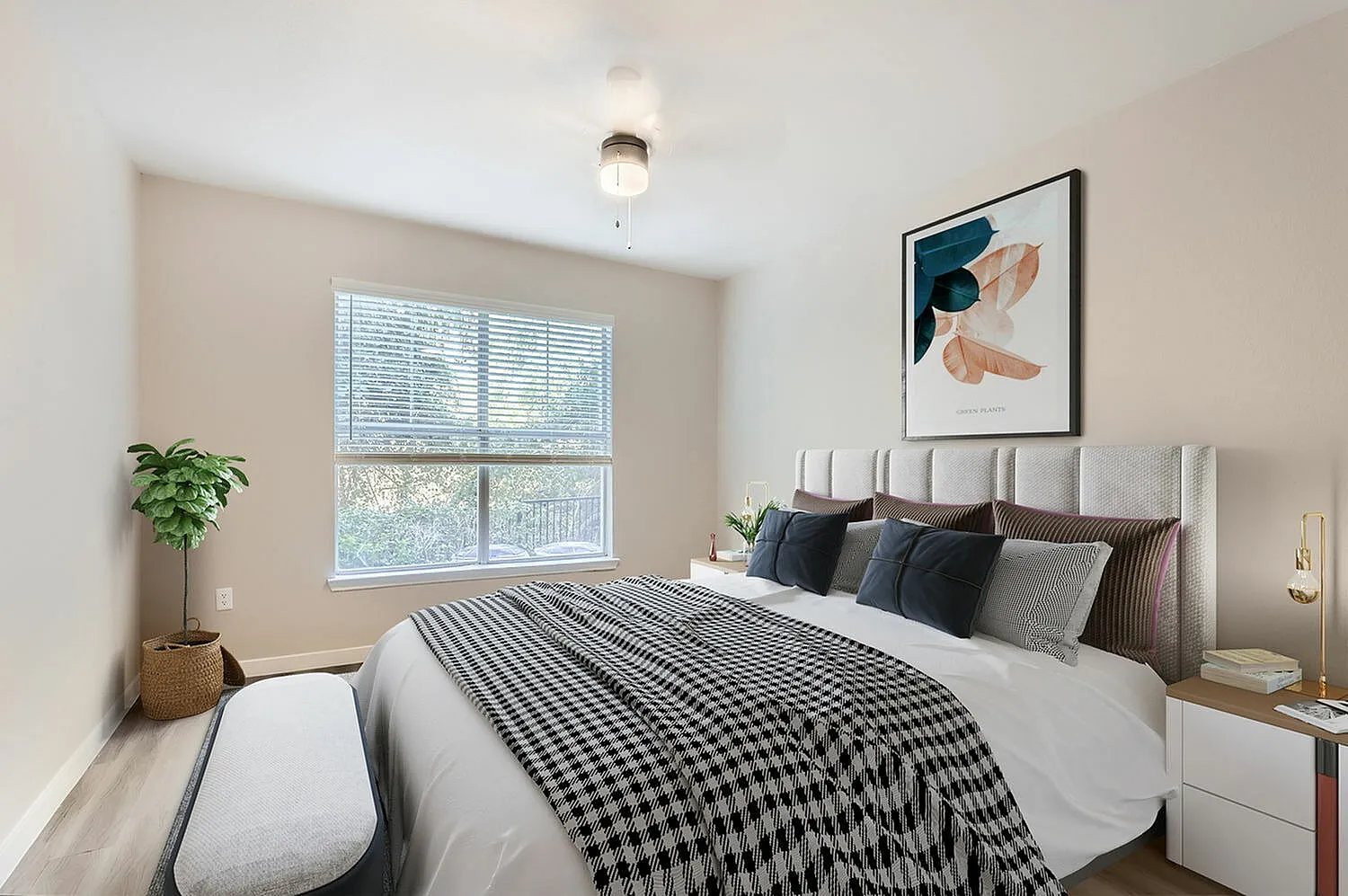 Primary bedroom with upholstered headboard, patterned bedding, wood-style plank flooring, large window