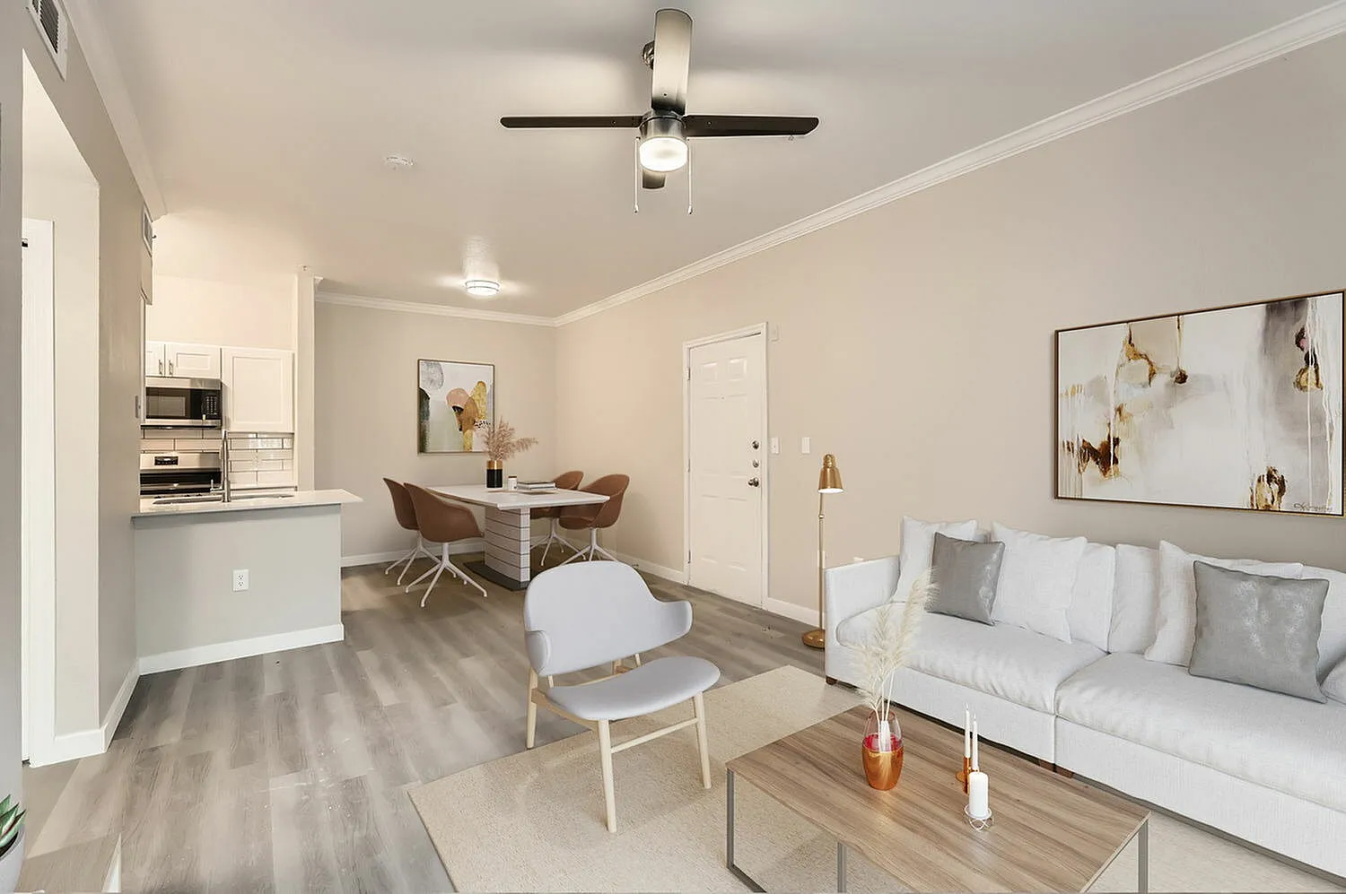 Open floor plan with kitchen, wood-style plank flooring, white cabinetry, ceiling fan, sofa