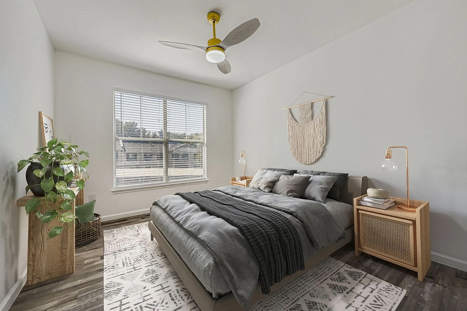 Primary bedroom, wood-style plank flooring, brass ceiling fan, large windows