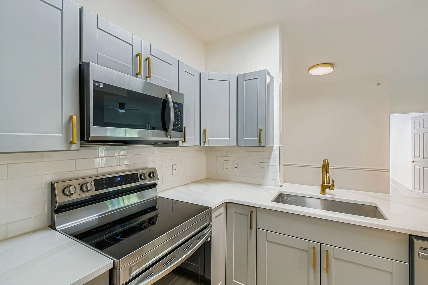Kitchen, gray shaker cabinetry, white quartz countertops, stainless steel appliances, subway tile backsplash, gold hardware