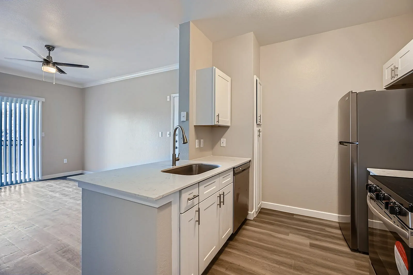 Kitchen, white shaker cabinetry, quartz countertops, stainless appliances, wood-style plank flooring