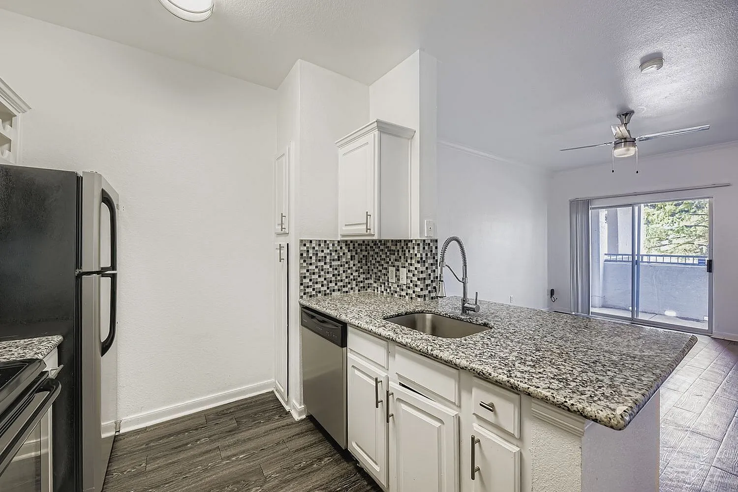 Kitchen, white shaker cabinetry, granite countertops, stainless appliances, wood-style plank flooring