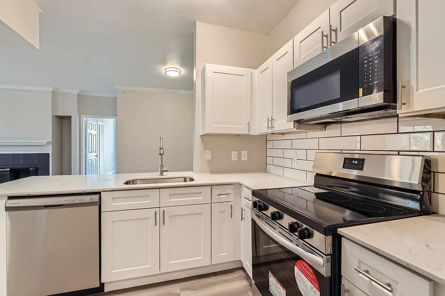 Kitchen, white shaker cabinetry, white subway tile backsplash, stainless appliances, quartz countertops