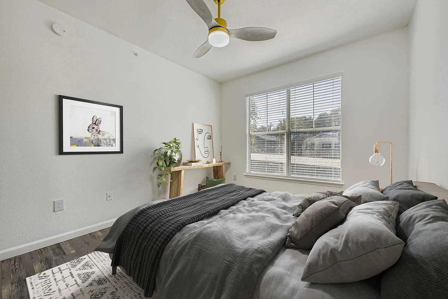 Primary bedroom, wood-style plank flooring, large windows with shutters, ceiling fan