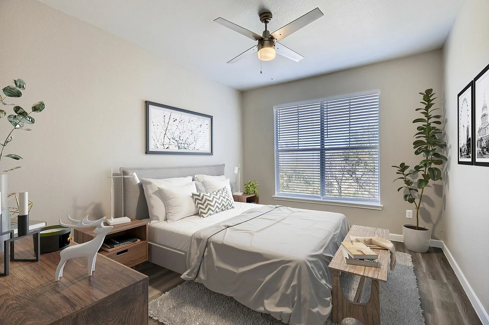 Primary bedroom, wood-style plank flooring, ceiling fan, large windows with shutters, potted plants